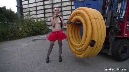 Cute blonde in heels and stockings smokes outdoor