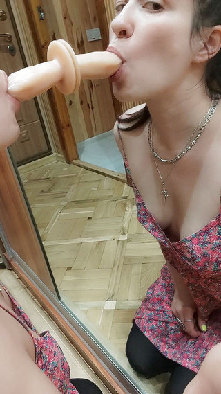 Sucking dildo on the mirror